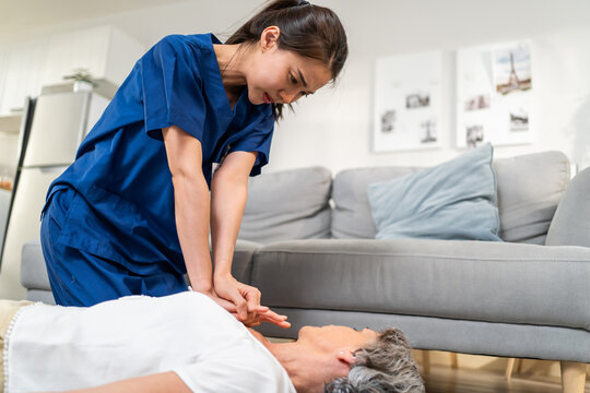 Asian caregiver saving senior woman's life by doing cpr in emergency.