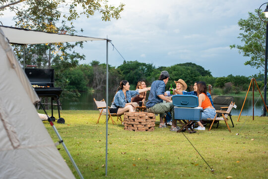 Group of diverse friend having outdoors camping party together in tent. 