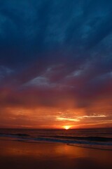 A beautiful combination of clouds and sun on a Florida beach during sunrise in a portrait shot