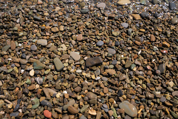 Sea pebbles on the Black Sea coast of the Krasnodar Territory resort on a sunny day, Sochi, Krasnodar Krai, Russia