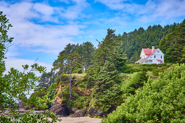 Secluded Coastal White House on Forested Cliff Viewed from Below