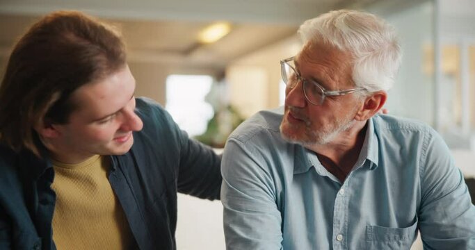 Senior, man and sad with support from son with comfort, conversation and crying with grief on sofa in home. Elderly, person and console for suffering, depression and empathy on couch in living room