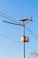 metal pole with common lights and cables with sky background