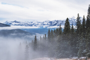 Dramatic landscapes in the Canadian Rocky Mountains with fog on the background of high mountain lakes
