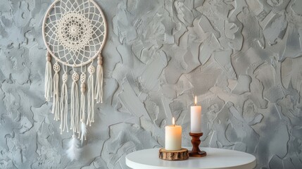 Fototapeta premium Close up of white nightstand and candlestick with cream crochet doily dreamcatcher on textured gray background Textured concrete with open space for text