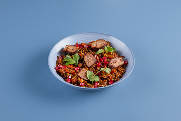 Minimalist Beef and Pomegranate Pilaf on Blue Background