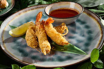 Shrimp Wrapped in Kataifi Dough with Dipping Sauce on Tropical Leaf Background
