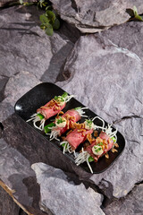 Gourmet Roast Beef Rolls with Daikon and Cucumber on Stone Slate