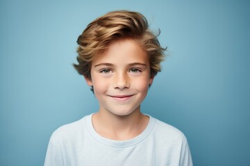 Fototapeta premium Portrait of cute little boy with blond hair on blue background.