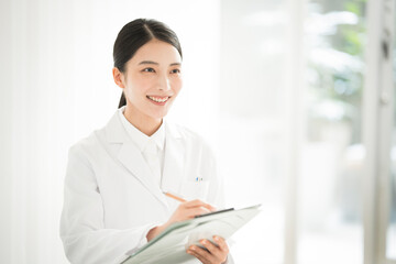 白衣を着た女性がカウンセリングをしている。