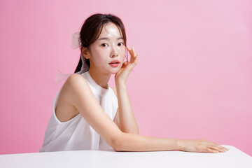 ピンク背景で撮影をした若い女性の軽やかなビューティー ポートレート