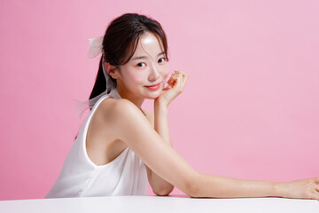 ピンク背景で撮影をした若い女性の軽やかなビューティー ポートレート