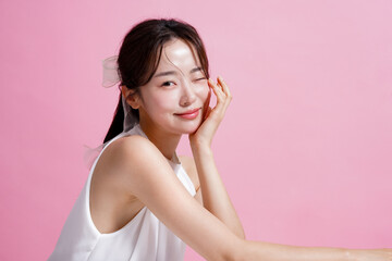 ピンク背景で撮影をした若い女性の軽やかなビューティー ポートレート