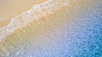 Top view beach sand background for summer vacation concept. Beach nature and summer seawater with sunlight light sandy beach Sparkling sea water