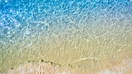 Top view beach sand background for summer vacation concept. Beach nature and summer seawater with sunlight light sandy beach Sparkling sea water