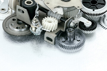 gears cogwheels and other parts of industrial machinery on scratched metal background.