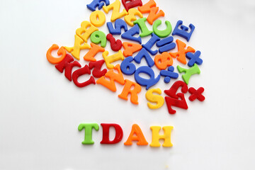 Colored toy letters for children form the word TDAH which means Attention Deficit Hyperactivity...