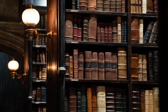 JAPAN - Nov 13, 2023: Hogwarts library with vintage bookshelves filled with old leather bound books illuminated by antique wall lamps at Warner Bros. Studio Tour Tokyo, The Making of Harry Potter