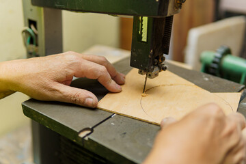 A man is using a woodworking machine to cut a piece of wood. Concept of craftsmanship and precision, as the man carefully operates the machine to create a precise cut