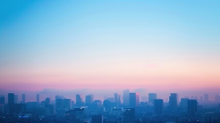 A soft-focus photo of a city skyline with buildings silhouetted against a gradient of blue evening sky