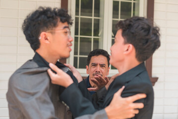 A father tries to break up a fight between his two sons outside a house. Emotions run high as the conflict unfolds.