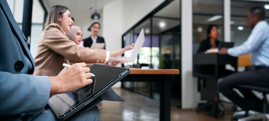 Closeup buisness people using digital tablet with stylus pen sitting in boardroom, panoramic view.
