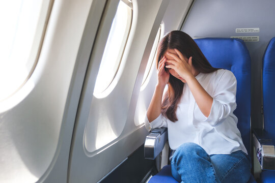 Portrait image of a woman get airsick and headache while traveling on airplane