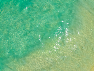 Aerial view of amazing sea surface water texture background,Sun reflections over ocean, Aerial flying drone view Waves water surface texture on sunny tropical ocean in Phuket island Thailand