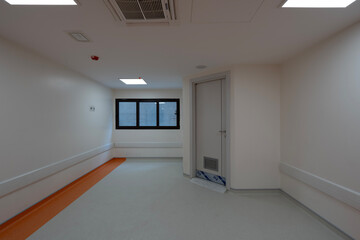 Vibrant empty hospital rooms with modern orange and grey flooring, radiating a calming yet professional atmosphere