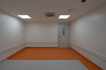 Vibrant empty hospital rooms with modern orange and grey flooring, radiating a calming yet professional atmosphere
