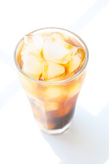 a glass of iced coffee on a white table