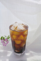 a glass of iced coffee on a white table