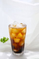 a glass of iced coffee on a white table