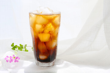 a glass of iced coffee on a white table