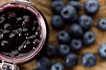 Blueberry jam with fresh berries on rustic wooden table background. Selective focus.