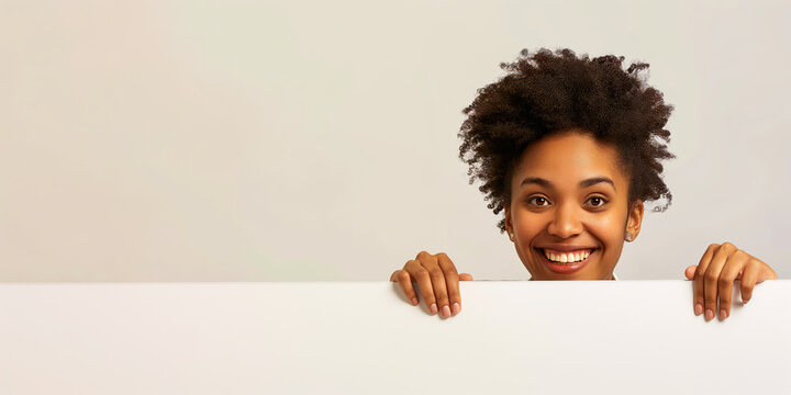 Smiling woman peeking over a white edge, neutral white background.