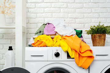 Pile of Laundry Awaiting Washing Machine in White Brick Laundry Room