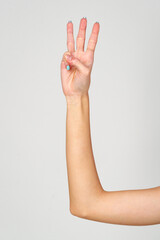 Womans Hand With Blue Nail Polish on gray background.