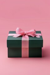 Obraz premium A green gift box with pink ribbon creates an elegant and luxurious atmosphere. The overall composition is symmetrical, highlighting the contrast between dark green and soft pink