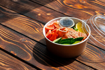 Poke bowl with salmon on wooden background