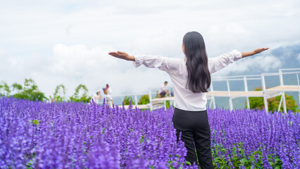 asian woman finds peace and joy in a lavender field during rainy season, embracing nature beauty for a serene purple background