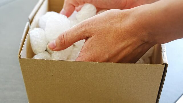 Eco packaging of parcels and white biodegradable filler. Box is filled with a filler safety for environment. Delivery of goods, parcels, delivery service, nature protection and recycling concept