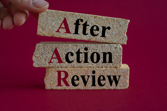 Concept words AAR After action review on brick blocks. Beautiful pink background, businessman hand. Business AAR after action review concept.
