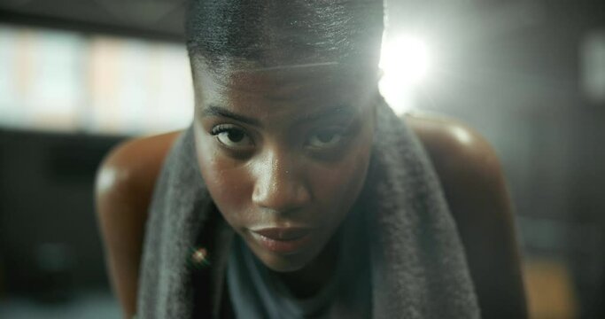 Face, sweating and towel with woman in gym for start of exercise, training or workout routine. Breathing, challenge and portrait of African person in health club for improvement or performance