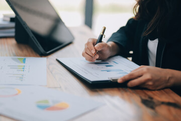 Pretty young Asian businesswoman sitting in office using laptop computer.