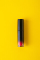 Close up of lip gloss, isolated on yellow background. 