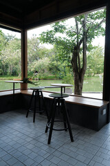 Outdoor dining space area of Restaurant terrace and coffee cafe with natural landscape of green lake view and cloudy blue sky
