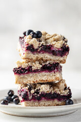 Baked oatmeal bars or crumble squares with fresh blueberry on white background, close up. Menu, recipe