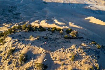 Poeple and american flag on top of giant sand dune in the Little Sahara Recreation Area, Nephi, Utah, United States of America.
