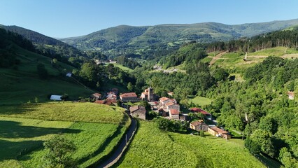 Peisaje de monta&ntilde;a con verde y arboles con un peque&ntilde;a aldea 